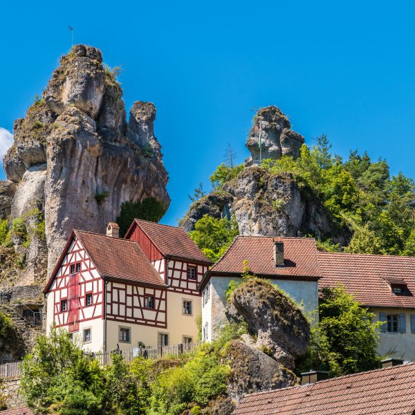 a group of houses on a hill with trees and rocks